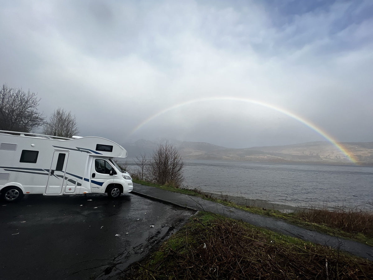 The Braw parked on the shore of Loch Lomond under a rainbow